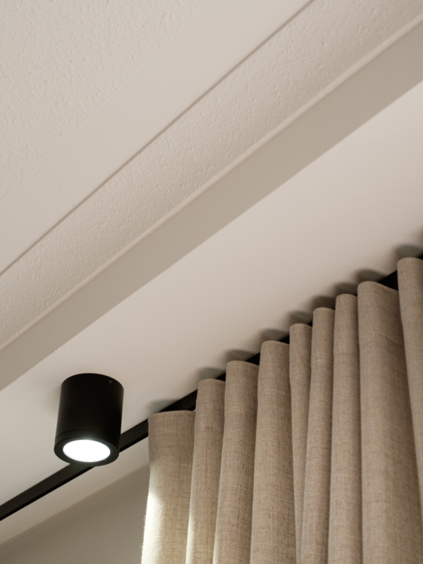 mariel-interior-olohuoneen-verhosuunnittelu-klaukkala-2024-1 Mustat metalliosat yhdistävät valaisimet, verhotangot ja muut metallielementit koko asunnon mitalta.