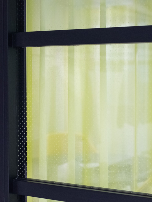 mariel-interior-pelialan-yritys-jello-neukkari-4 Jello-neuvottelutilan keltaiset verhot ja ikkunan mustat raamit.