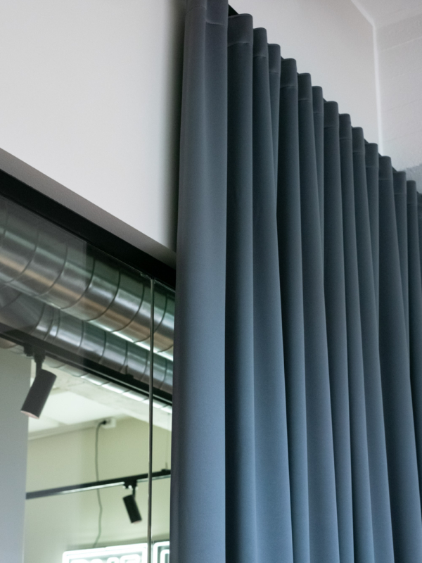 Neuvottelutilan verhot laskeutuvat kauniisti mustista kiskoista lattiaan asti.