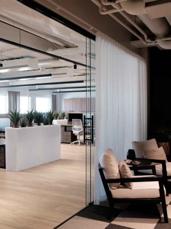 Takkahuoneen lasisein&auml; ja l&auml;pikuultavat verhot yhdist&auml;v&auml;t huoneen ty&ouml;tilaan.