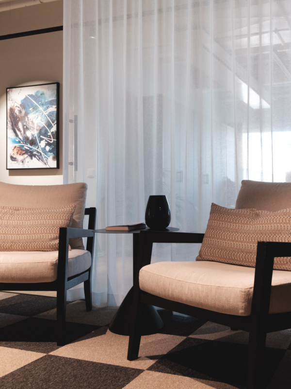 Takkahuoneen mukavat nojatuolit ja Lotta Sirenin taulu aulassa.