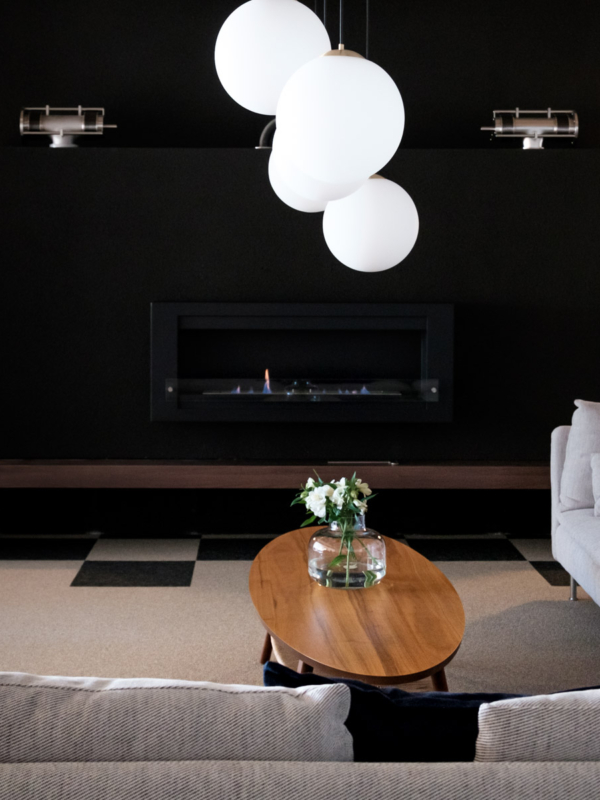 Takkauhuoneesta l&ouml;ytyy n&auml;ytt&auml;v&auml;&auml; kontrastia lattian, takan ja vaalean sohvan v&auml;lill&auml;.